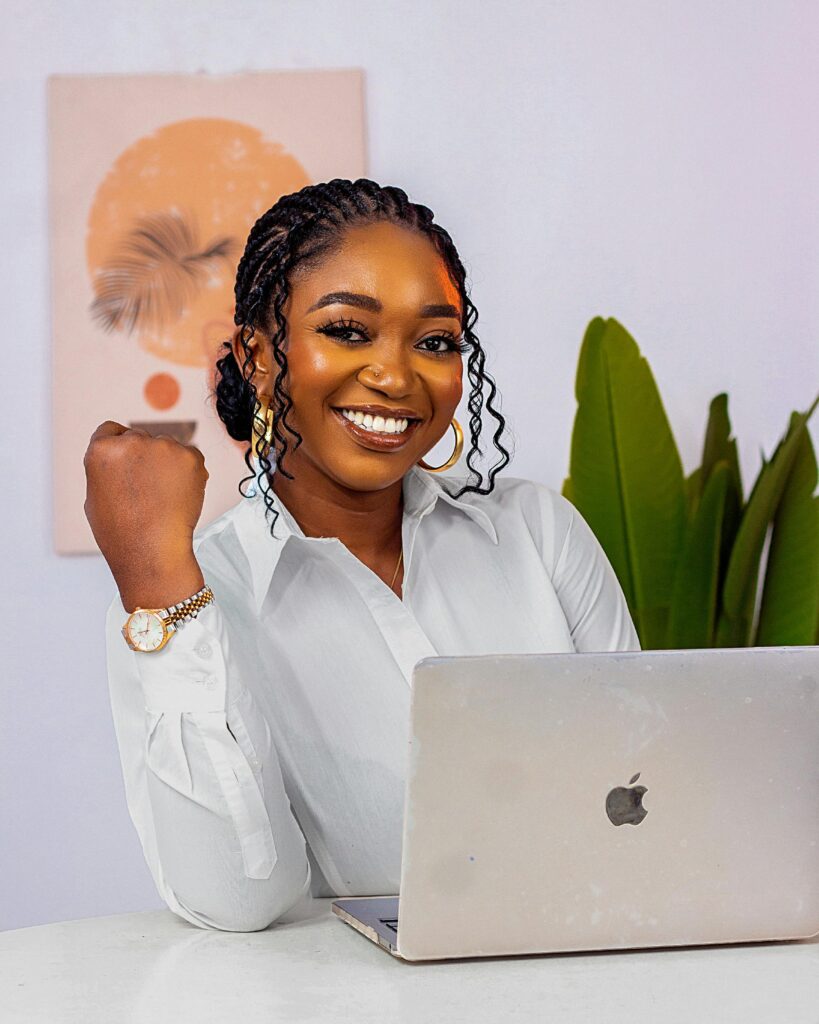 pexels-photo-34610771-34610771 Smiling businesswoman works confidently on a laptop in a creative office setting, embodying modern entrepreneurship.